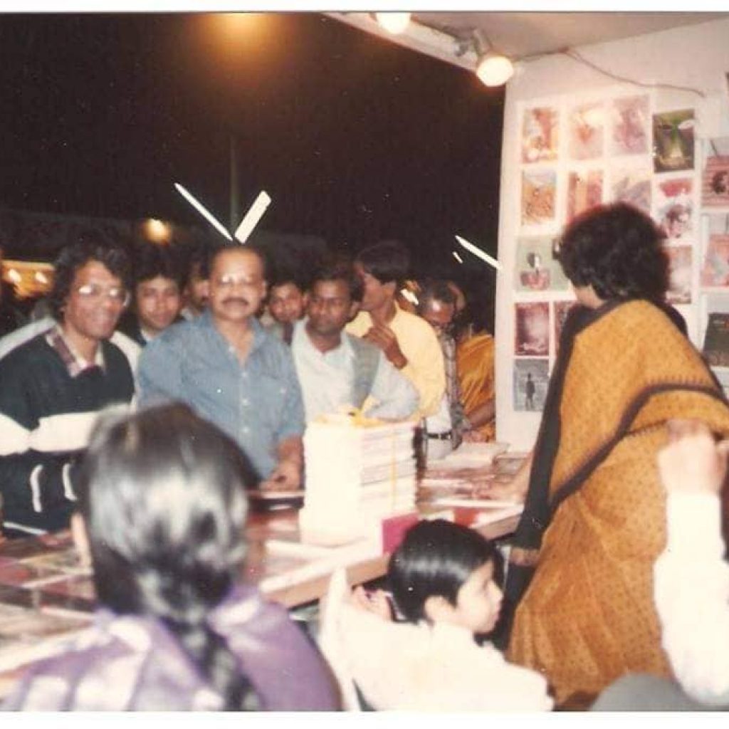 ছবি: ফেব্রুয়ারি ১৯৯২ সাল, একুশে বইমেলায় বিদ্যাপ্রকাশের সামনে ড. হুমায়ূন আজাদ ও ফজলুল আলম দেখা যাচ্ছে। ভিতরে তসলিমা নাসরিন, প্রকাশক মজিবর রহমান খোকার সহধর্মিনী নাসরিন সুলতানা, কন্যা মানসুরা সুলতানা দ্বিতীয়া। ফটোক্রেডিট : মজিবর রহমান খোকা