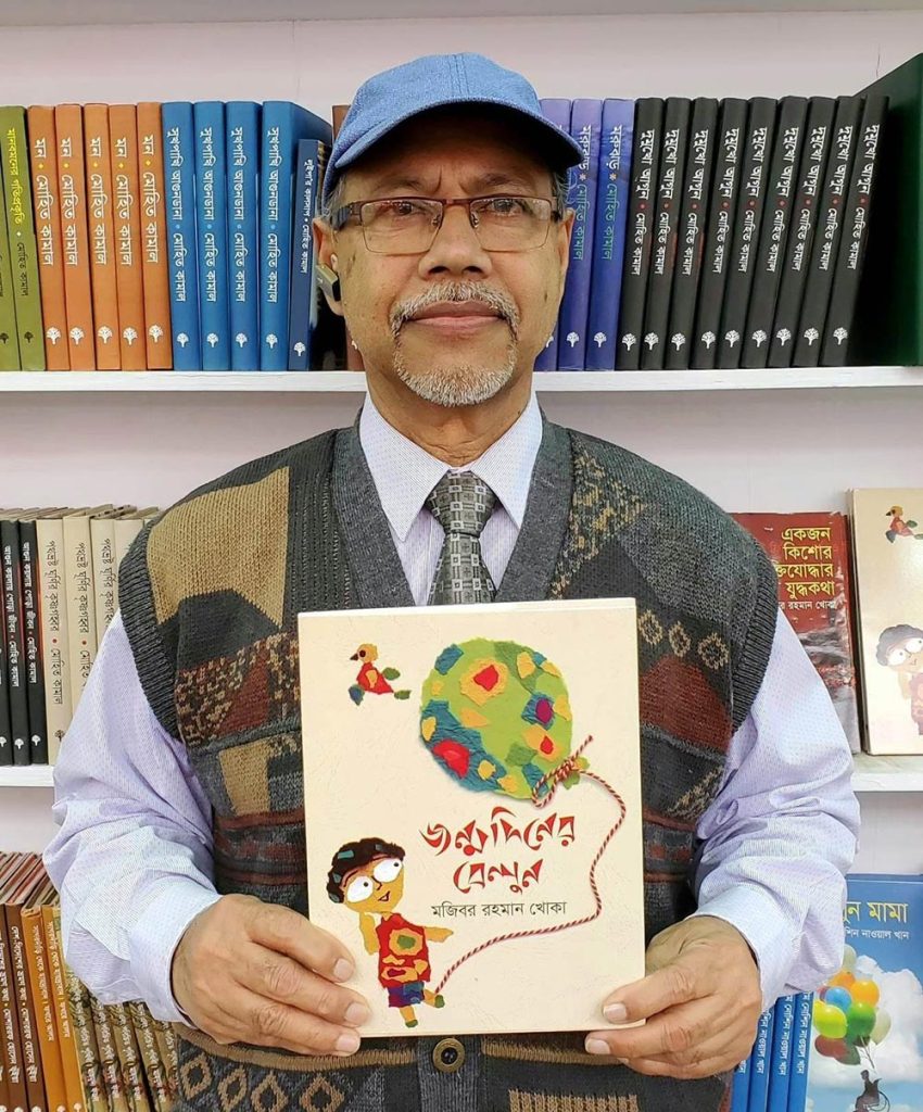 নিজের লেখা বই হাতে লেখক মজিবর রহমান খোকা